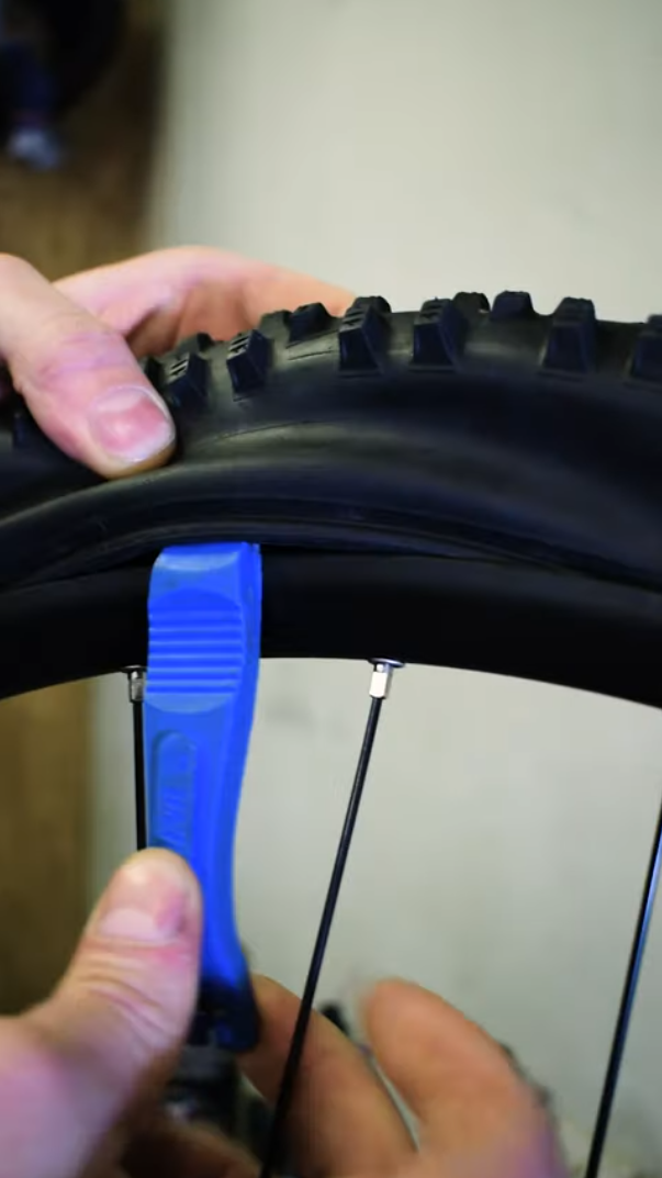 Zatikanje montirača za rob plašča pri menjavi zračnice. Zatikanje montirača za rob plašča pri menjavi zračnice.